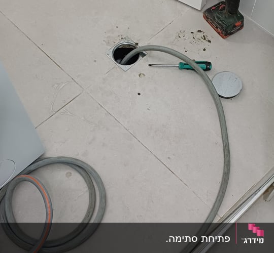 צינור וכלי עבודה על רצפת חדר אמבטיה